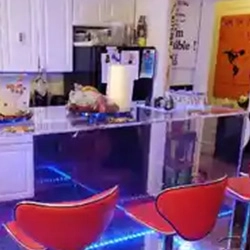 A kitchen with a bar and red chairs