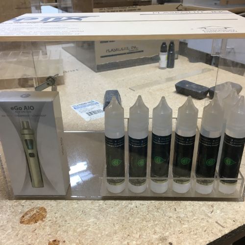 A display case with bottles of e-liquid and an electronic cigarette.