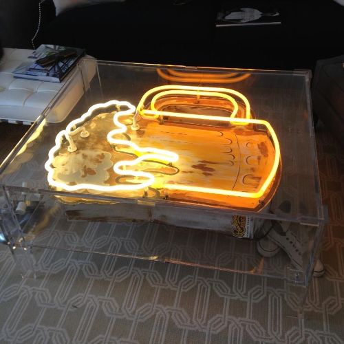 A neon sign sitting on top of a glass table.