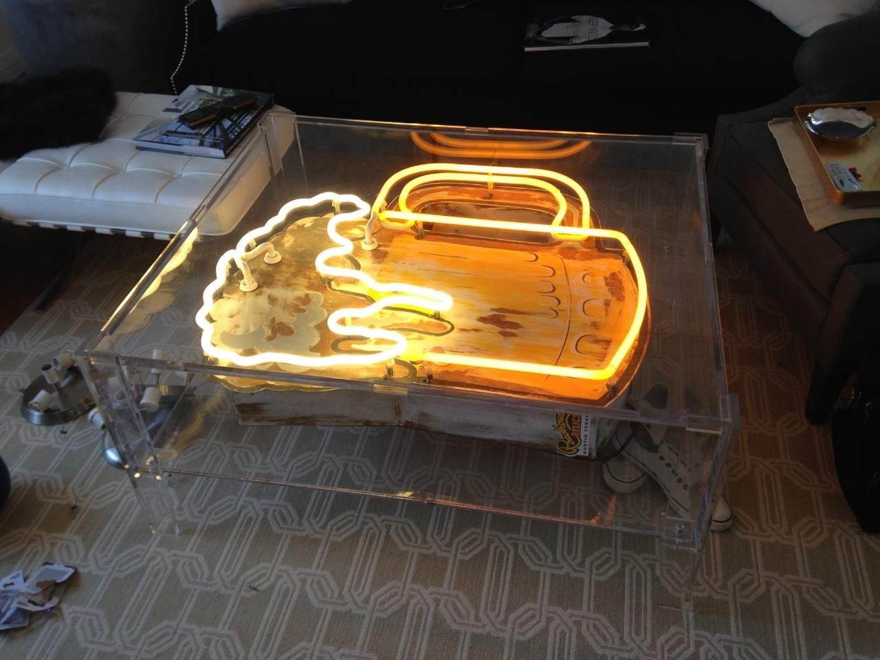 12-05-2017 014 A glass table with an orange neon sign on it.