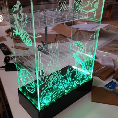 A display case with green lights on top of it.