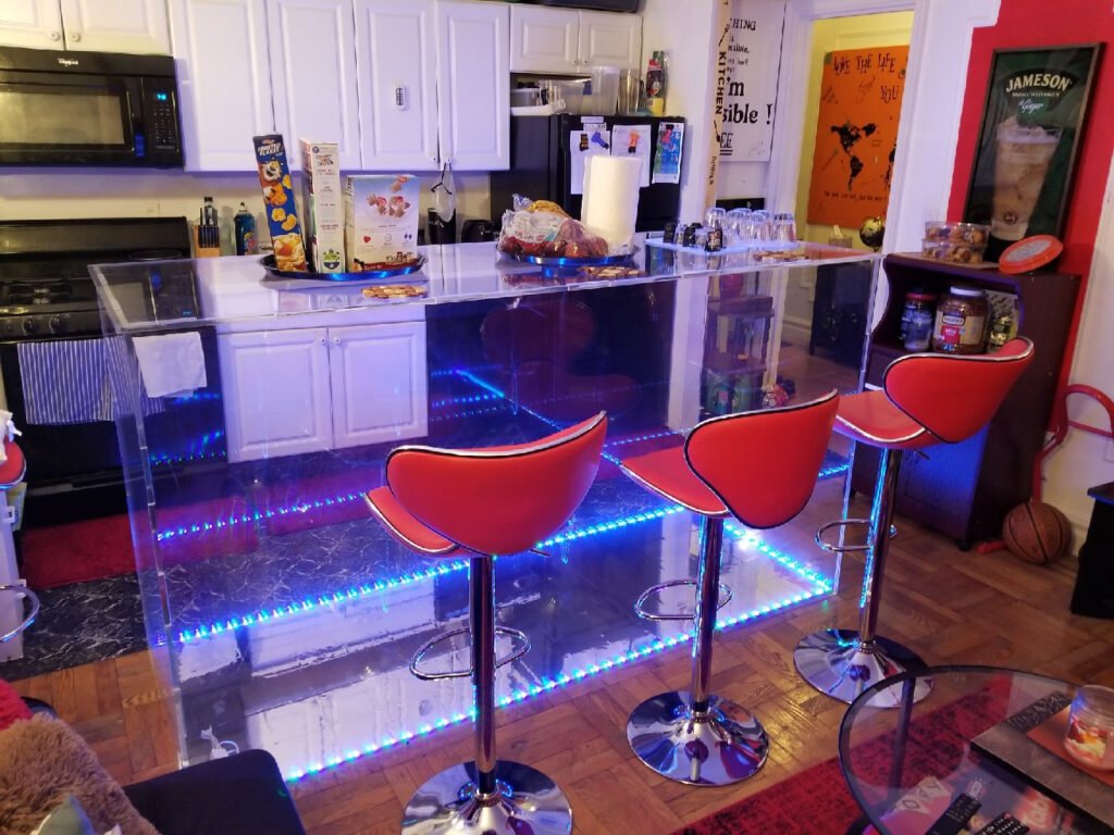 A kitchen with red chairs and blue lights