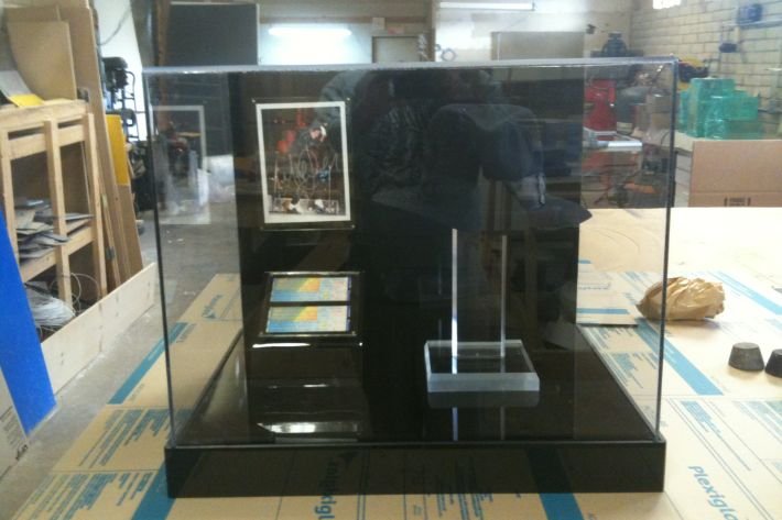 A display case with a cell phone and a picture.