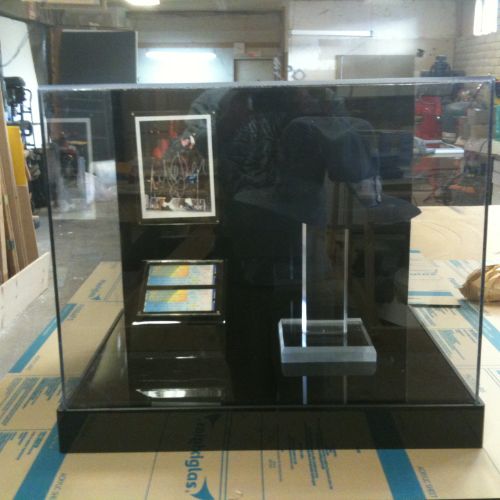 A display case with a cell phone and a picture.