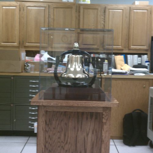 A large bell sitting on top of a wooden table.