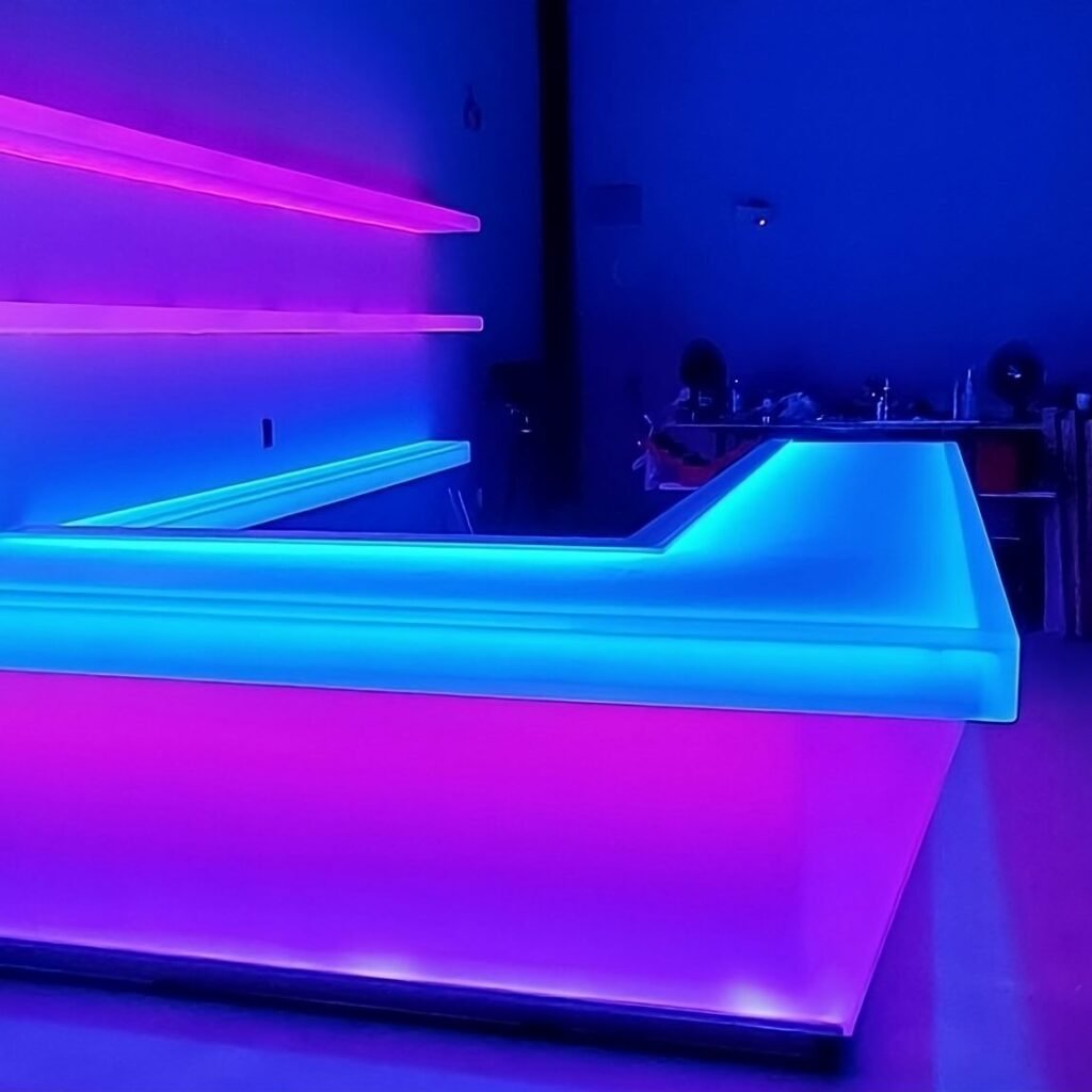 image0_(2124b0f2-769d-4f73-90fa-e231420ba02a)-transformed A bar with purple lights on the wall
