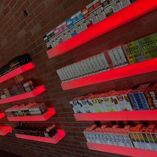 A wall of shelves with many different types of cigarettes.