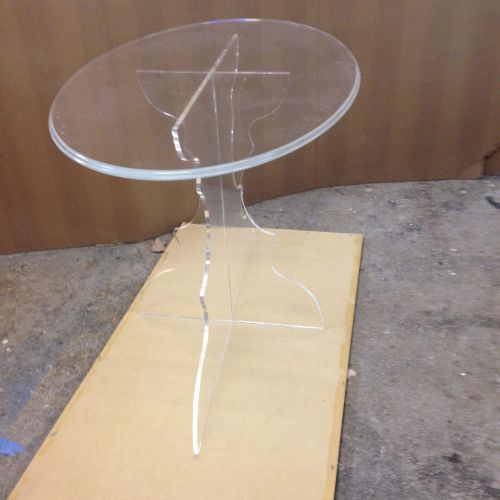 A round glass table with a clear base.