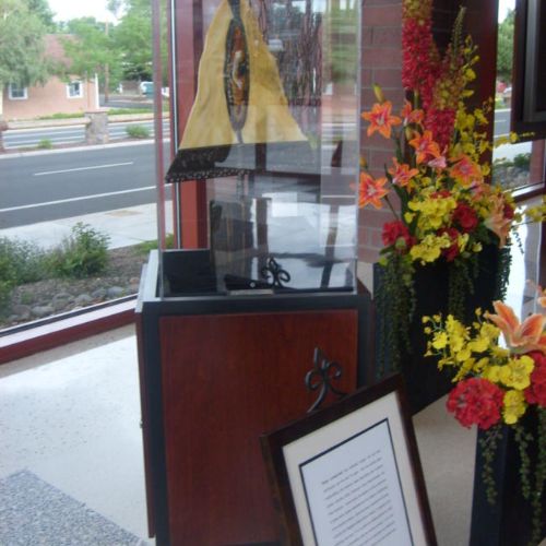 A display case with flowers and pictures on it.