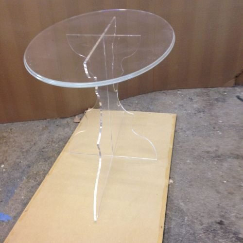 new-folder-020-scaled (1) A round glass table with a clear base.