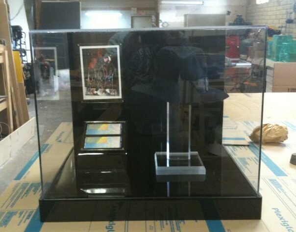 A display case with a cell phone and a picture.